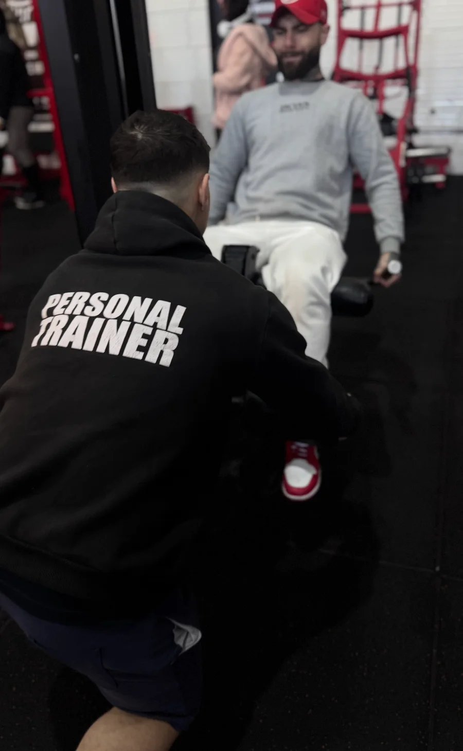 Gyancarlos acompanhando um aluno durante o treino na sala de musculação